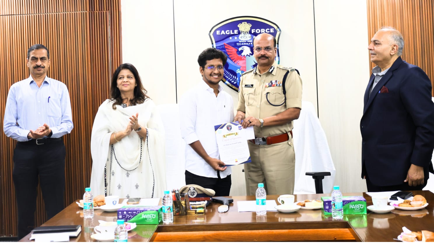 Dhadi Sai Praneeth Reddy receiving a certificate of appreciation from DGP Telangana Shri B. Shivadhar Reddy, IPS, in front of the EAGLE Force emblem at the launch of the Eagle Force website and AI platform
